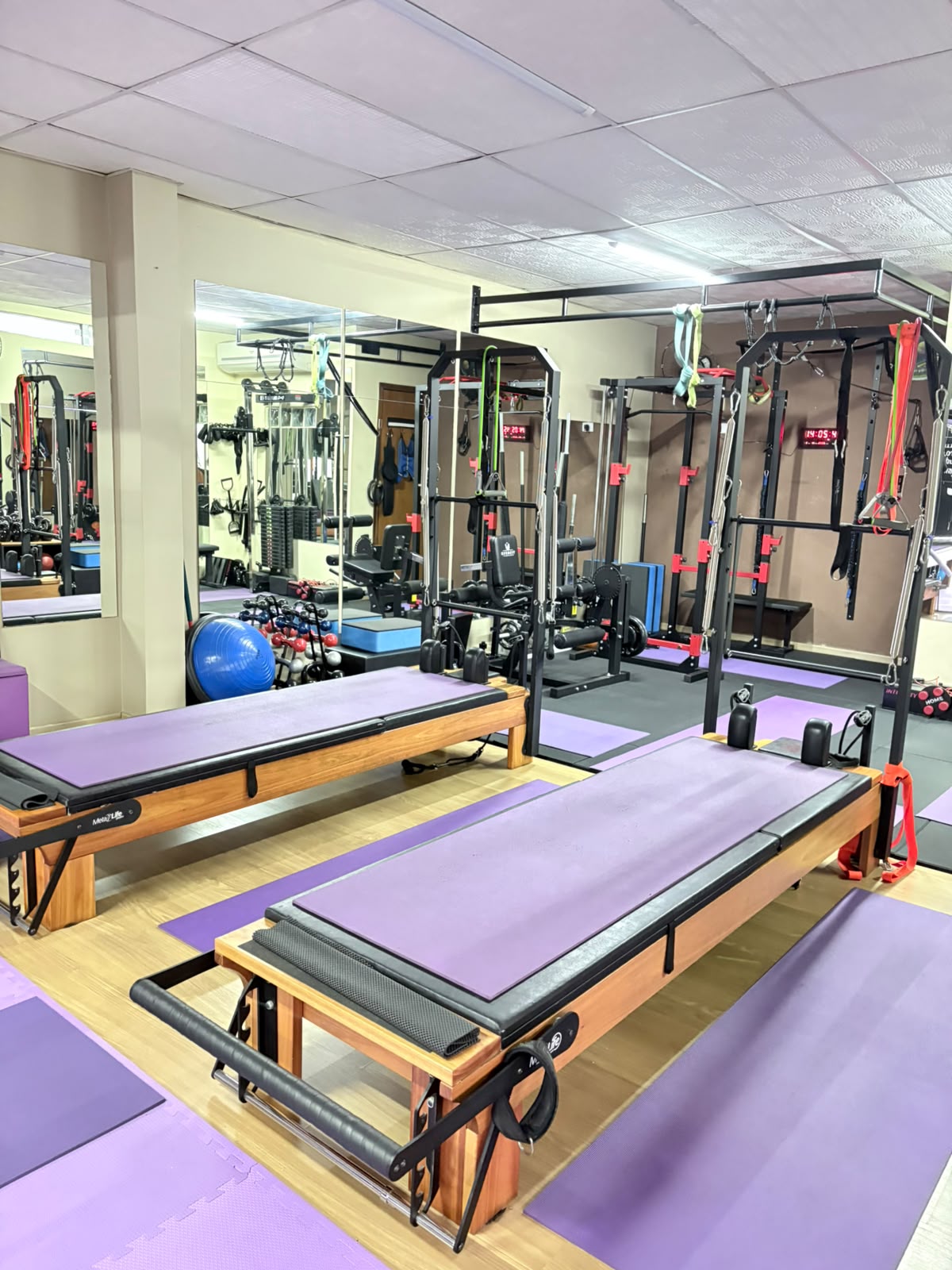 Vista panorâmica do estúdio com reformers de Pilates